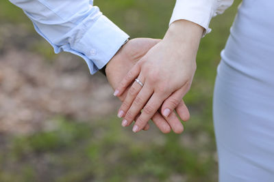 Midsection of couple holding hands