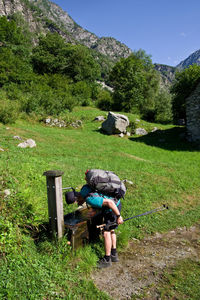 Hiker drinking water on field 