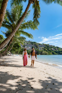 Rear view of women walking on beach