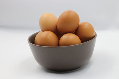Close-up of eggs in bowl against white background
