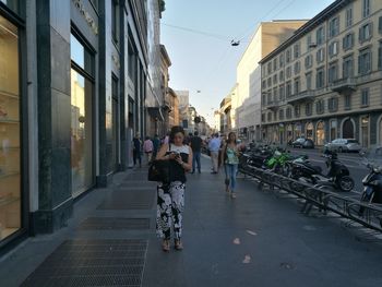 People walking on road along buildings