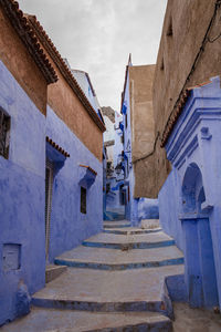 Low angle view of staircase amidst buildings against sky