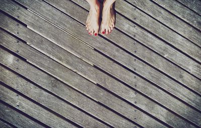 Low section of woman standing on wooden pier