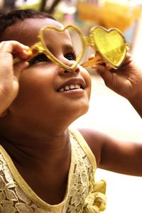 Close-up of girl looking through heart shape novelty glasses