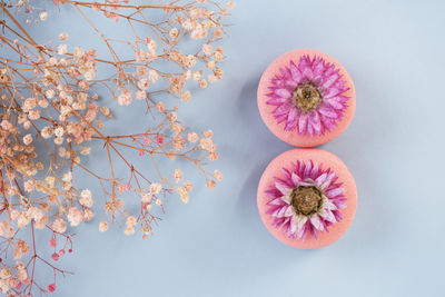 Two pink macaroons with flowers in the shape of the number 8 on blue background. greeting card