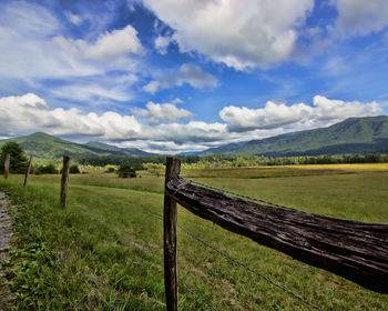 Wooden fence on field against sky