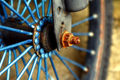 Close-up of rusty wheel against wall