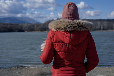 Rear view of woman standing against sea