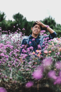 Midsection of person on purple flowering plants