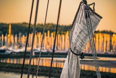 Close-up of sailboat against lake during sunset