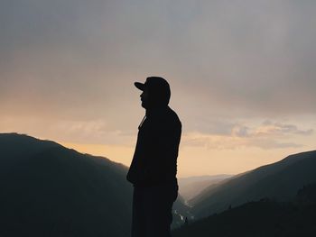 Rear view of silhouette man standing against sky during sunset