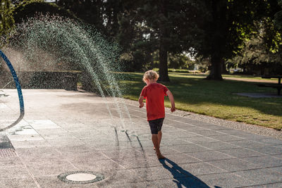 Child playing in a splash park on a summer day