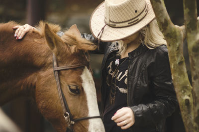 Young woman with horse on field