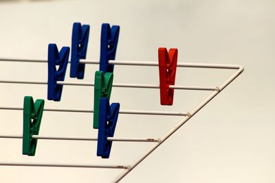 Close-up of clothespins on clothesline against clear sky