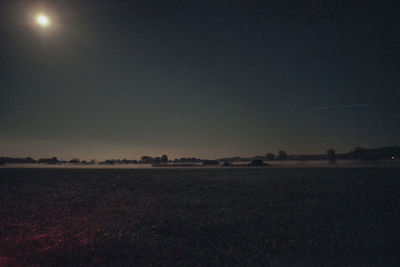 Scenic view of field against clear sky at night