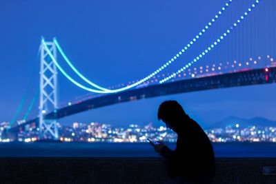 Suspension bridge over river at night