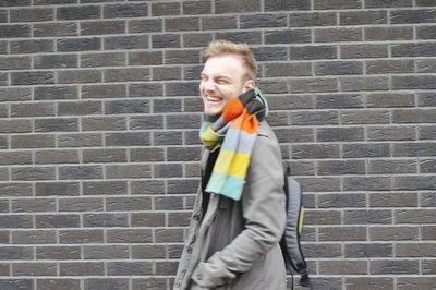 Boy standing against brick wall