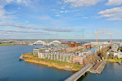 Scenic view of river by city against sky