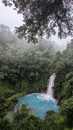 Scenic view of waterfall against sky