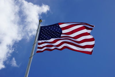 Low angle view of flag against blue sky