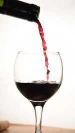 Close-up of wine glass against white background