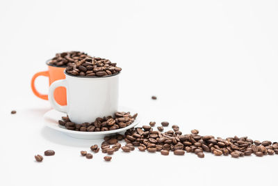 Coffee beans on table against white background