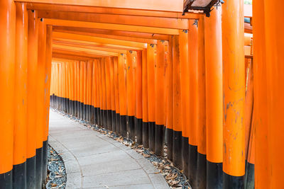 Footpath amidst buildings against orange sky