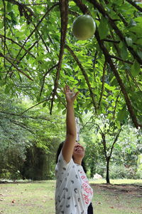 Low section of woman standing by tree