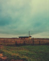 Fence on field against sky