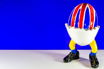 Close-up of stuffed toy on table against blue background