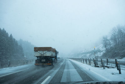 Road on snow covered landscape during rainy season