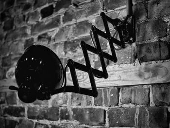 Low angle view of electric lamp against wall