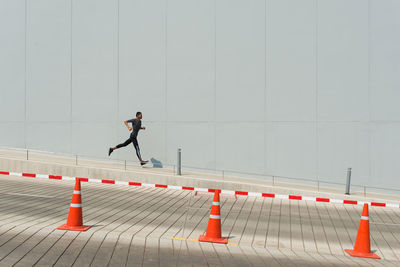 Side view of man with running on footpath