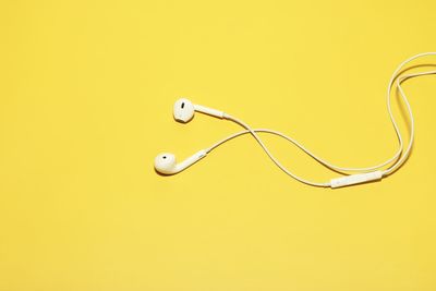 Close-up of electric bulb against yellow background