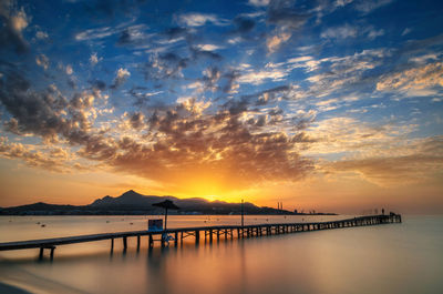 Reflection of clouds in sea at sunset