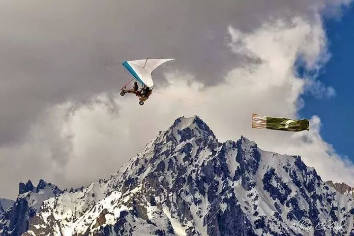 mountain, mid-air, flying, adventure, sky, extreme sports, leisure activity, transportation, cloud - sky, mountain range, low angle view, lifestyles, mode of transport, travel, air vehicle, snowcapped mountain, scenics, unrecognizable person