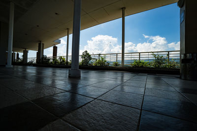 View of empty tiled floor against sky seen through window