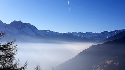 Scenic view of snowcapped mountains against clear blue sky