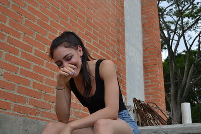 Low angle view of smiling woman sitting on steps