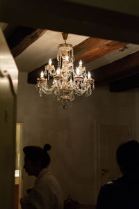 Rear view of illuminated chandelier hanging on ceiling