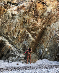 Rear view of woman standing on rock