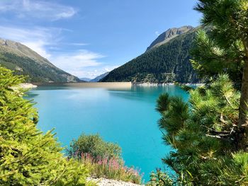 Scenic view of lake and mountains against blue sky