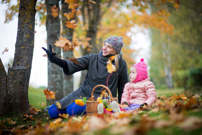 Mother with cute baby girl at park during autumn