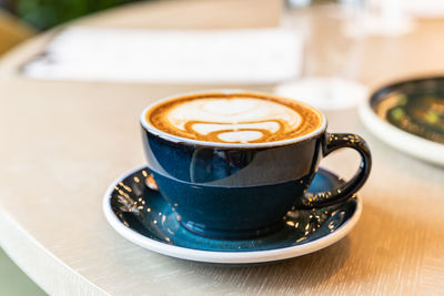 Coffee in ceramic cup on table in cafe or coffee shop.