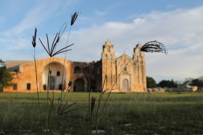 Built structure on field against sky