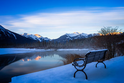 Scenic view of lake by snowcapped mountains against sky