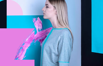 Close-up of woman standing against colorful background