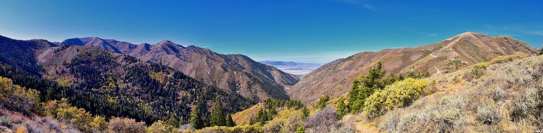 Panoramic view of mountain range against blue sky