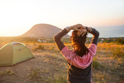 Woman meets the dawn in the mountains, rejoices in the sun. panoramic view of the mountain 