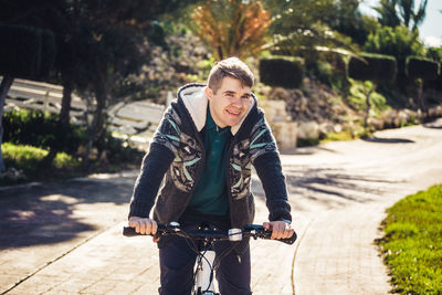 Portrait of man riding bicycle on road